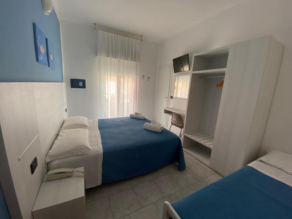 - une petite chambre avec 2 lits et un bureau dans l'établissement Hotel Stella Alpina, à Rimini