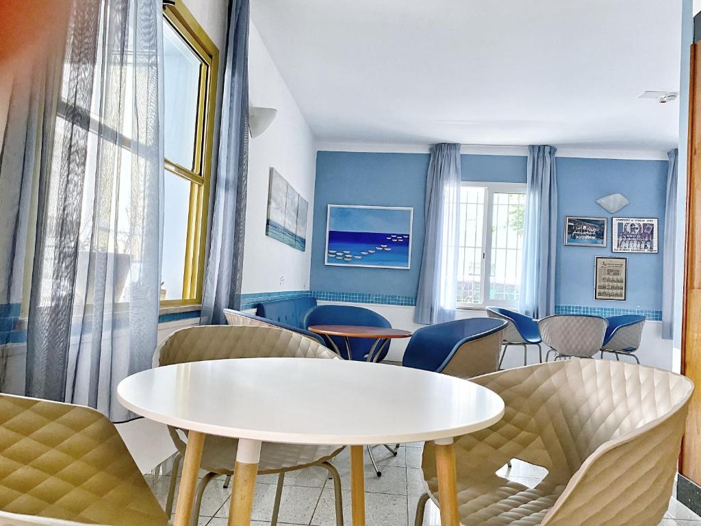 une salle d'attente avec une table et des chaises blanches dans l'établissement Hotel Stella Alpina, à Rimini