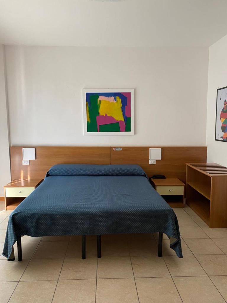 - une chambre dotée d'un lit bleu et d'une peinture murale dans l'établissement Hotel Ivana, à Lido di Jesolo