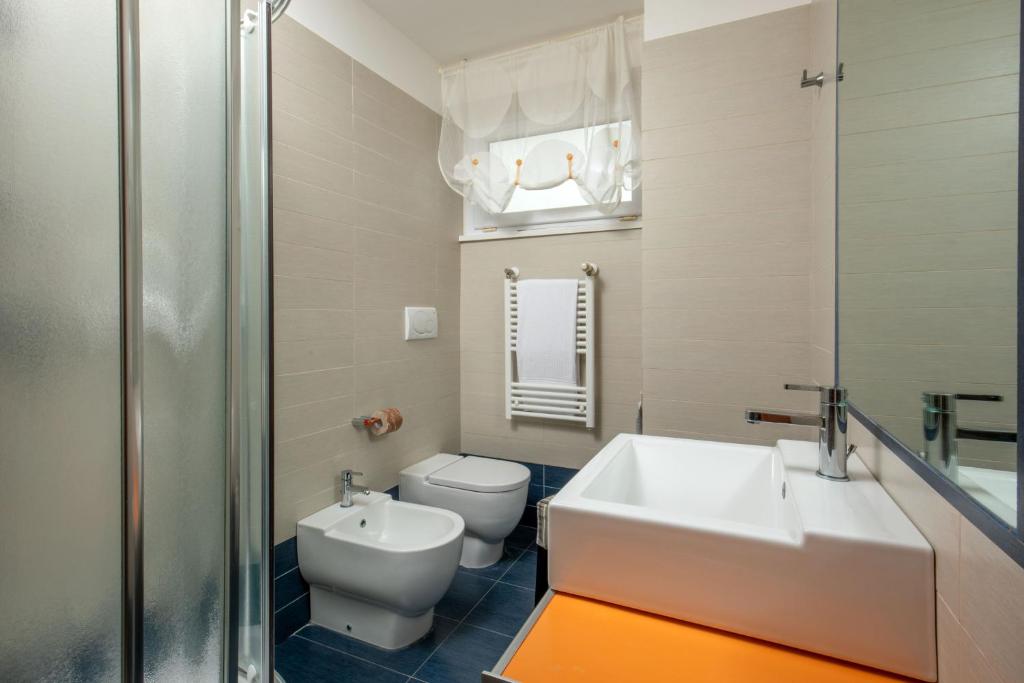 une salle de bain avec un lavabo et des toilettes dans l'établissement Hotel Miramare, à Latina