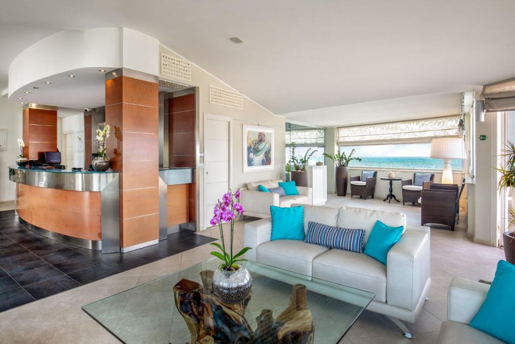 un salon avec un canapé et une table dans l'établissement Hotel Miramare, à Latina