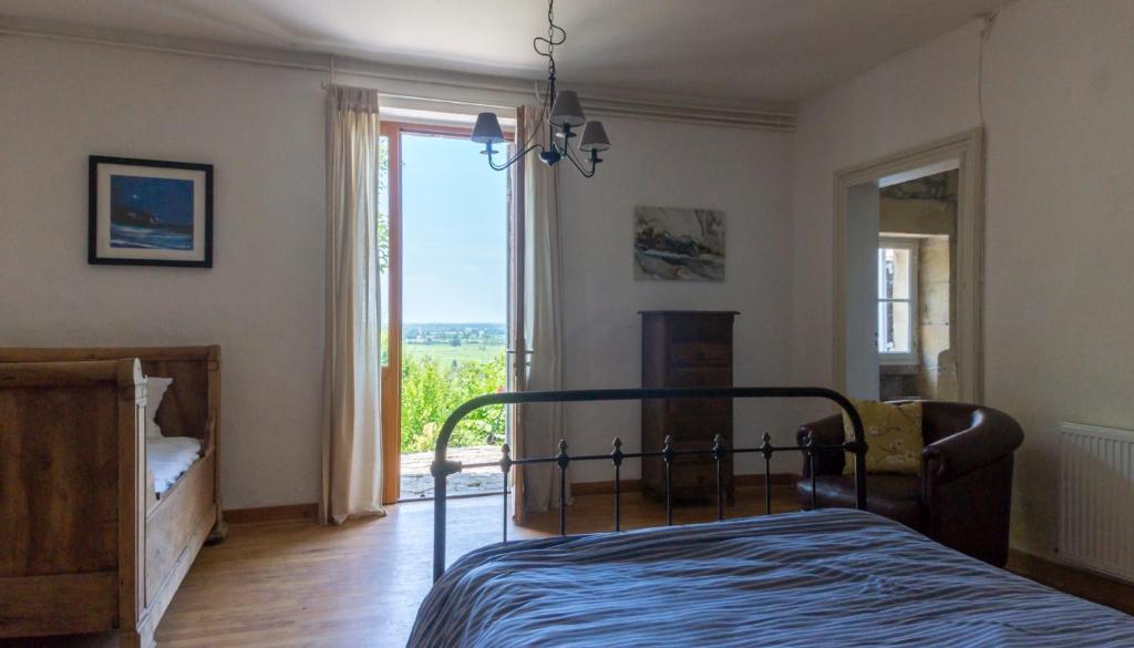 une chambre avec un lit et une grande fenêtre dans l'établissement Romantic Gite nr St Emilion with Private Pool and Views to Die For, à Pujols Gironde