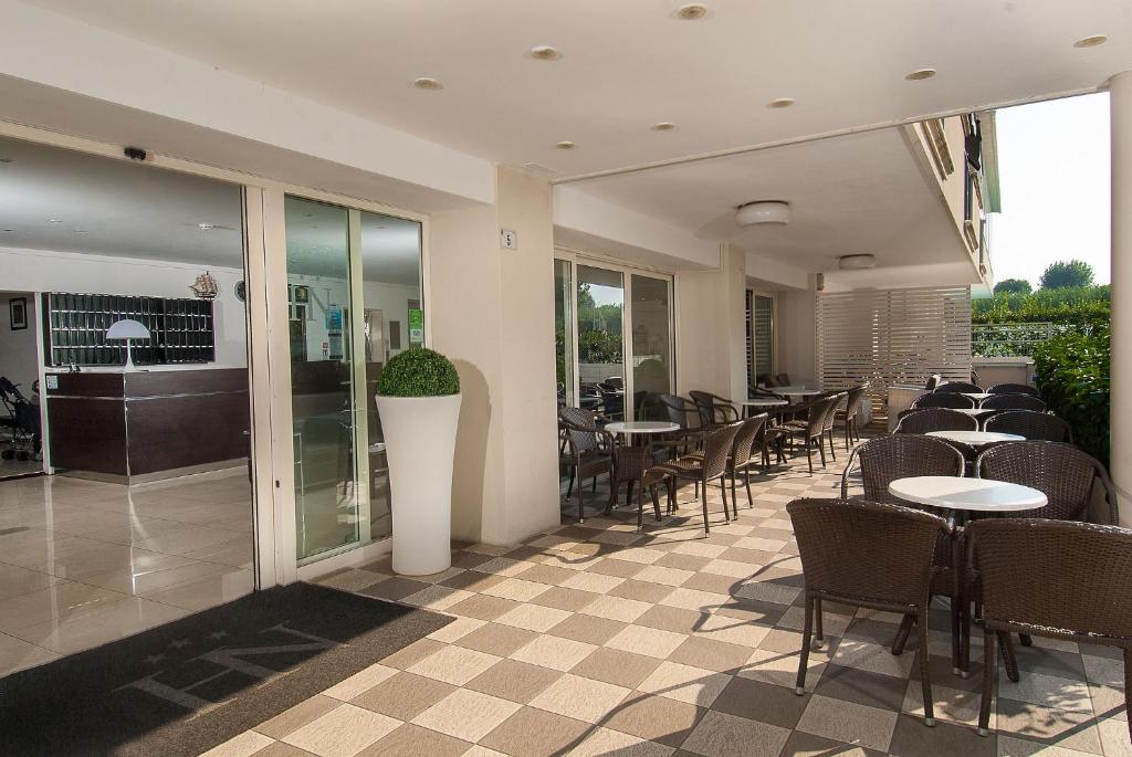 un restaurant avec des tables et des chaises dans une salle dans l'établissement Hotel Niagara, à Cattolica
