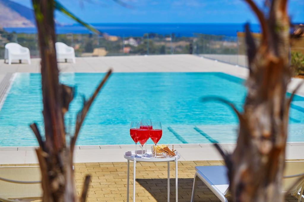 - deux verres de vin assis sur une table à côté d'une piscine dans l'établissement Villa Etesiae, à Castellammare del Golfo