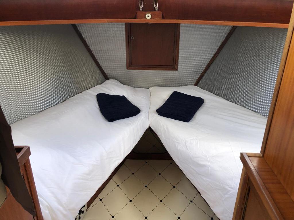 - 2 lits dans une petite chambre avec des oreillers noirs dans l'établissement La Vedette Hollandaise, à Étaples