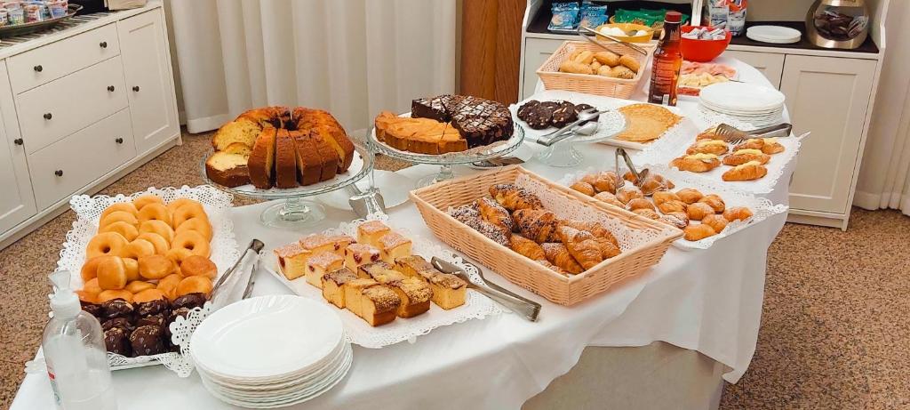une table remplie de différents types de pâtisseries et de desserts dans l'établissement Hotel Ammare, à Sottomarina