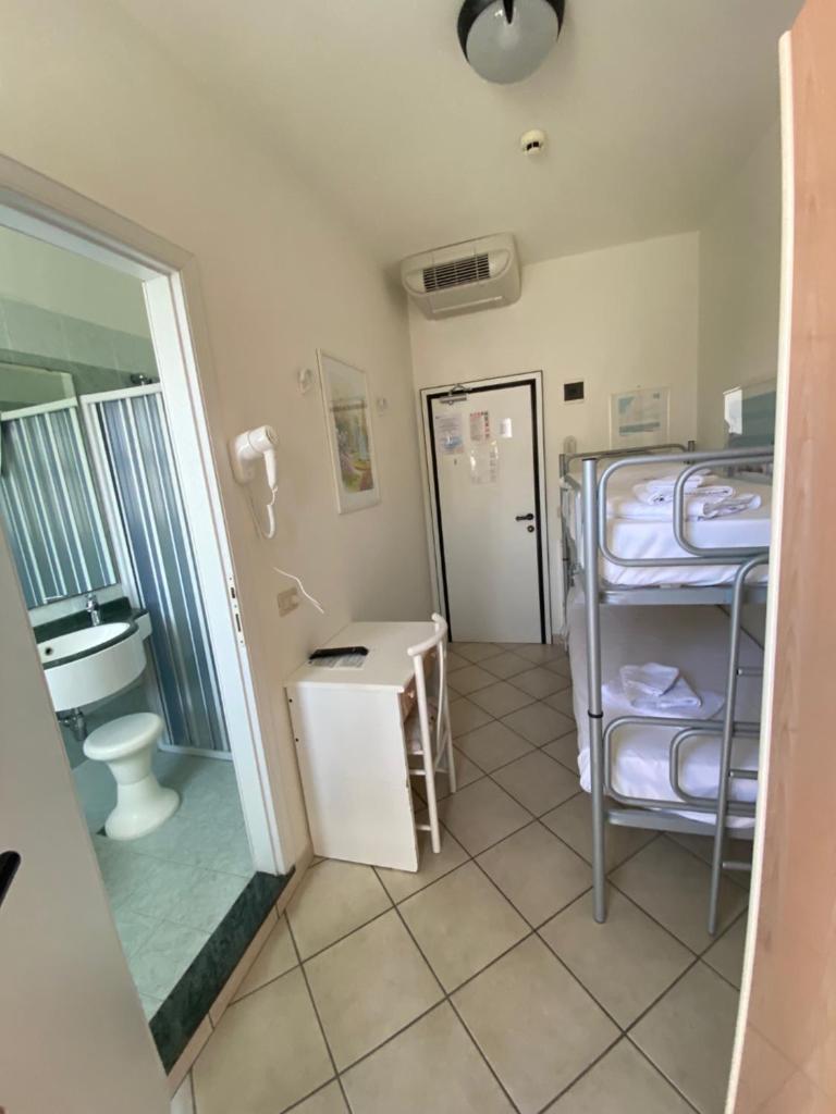 une salle de bain avec deux lits superposés et un WC dans l'établissement Hotel Christian Ideale Per Famiglie, à Riccione