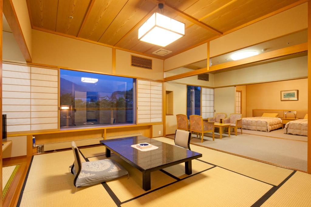 un salon avec une table et une chambre dans l'établissement Zazan minakami, à Minakami