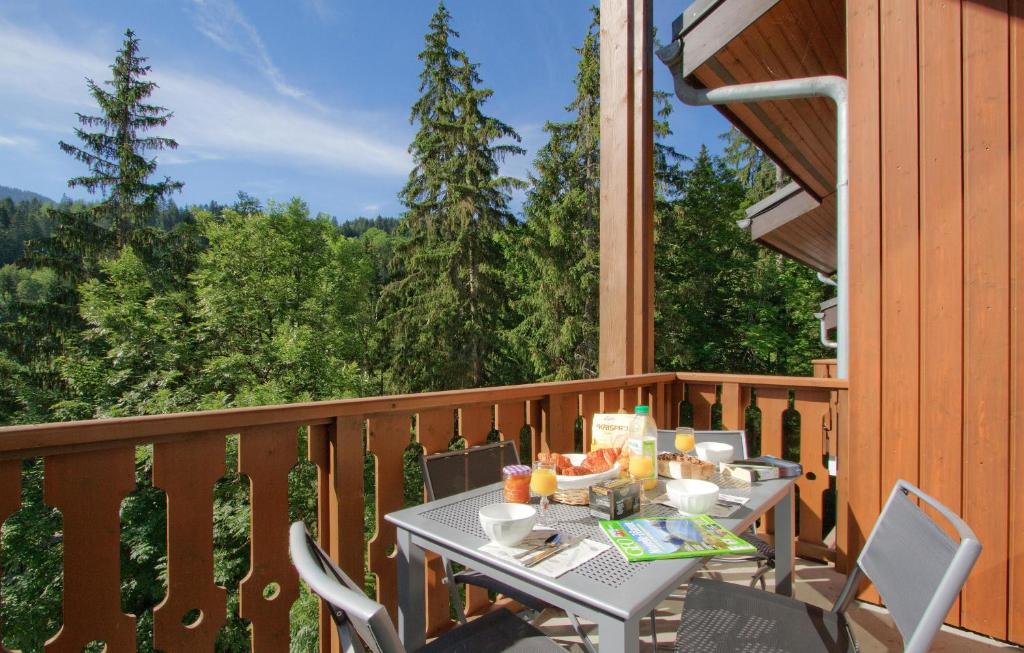 - une table sur un balcon avec une table et des chaises dans l'établissement Résidence Odalys Le Buet, à Morillon