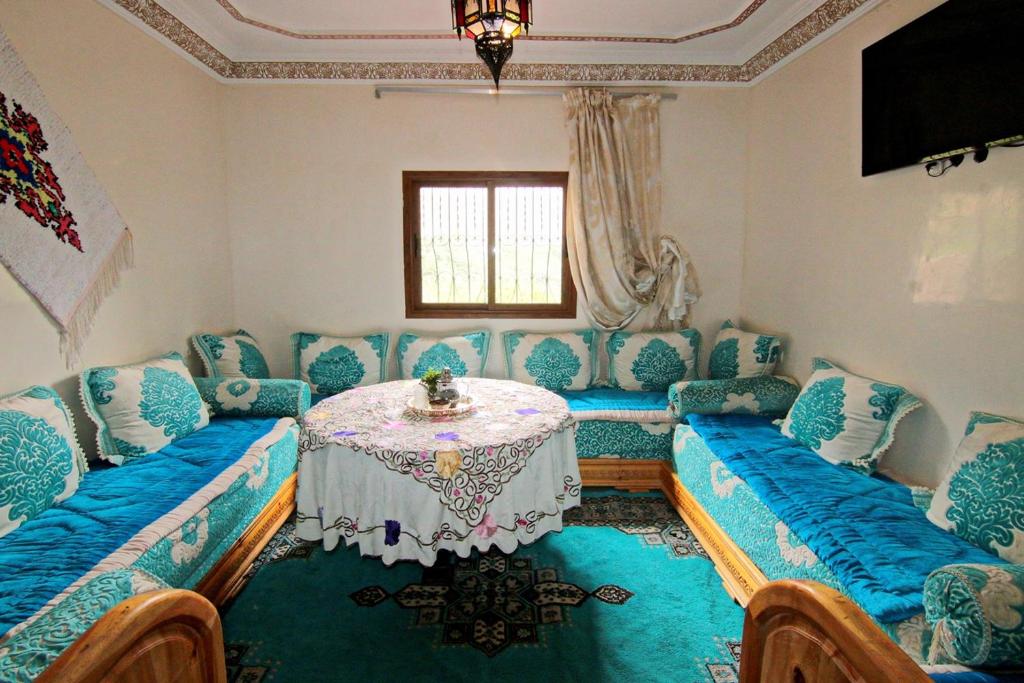 un salon avec une table et des chaises bleues dans l'établissement Jnane Karma, à Imlil