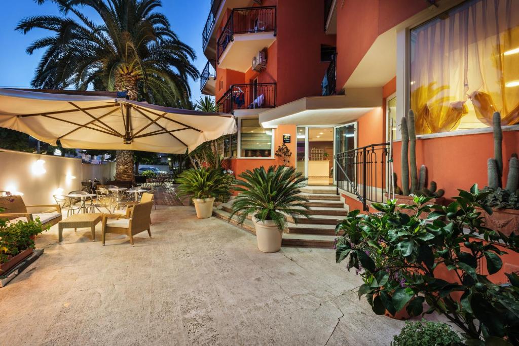 une terrasse avec une table et un parasol dans l'établissement Hotel Fenix, à San Benedetto del Tronto