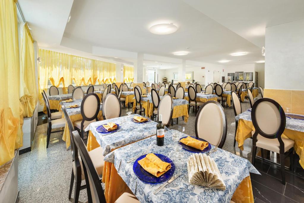 une salle de banquet avec des tables et des chaises dans une pièce dans l'établissement Hotel Fenix, à San Benedetto del Tronto