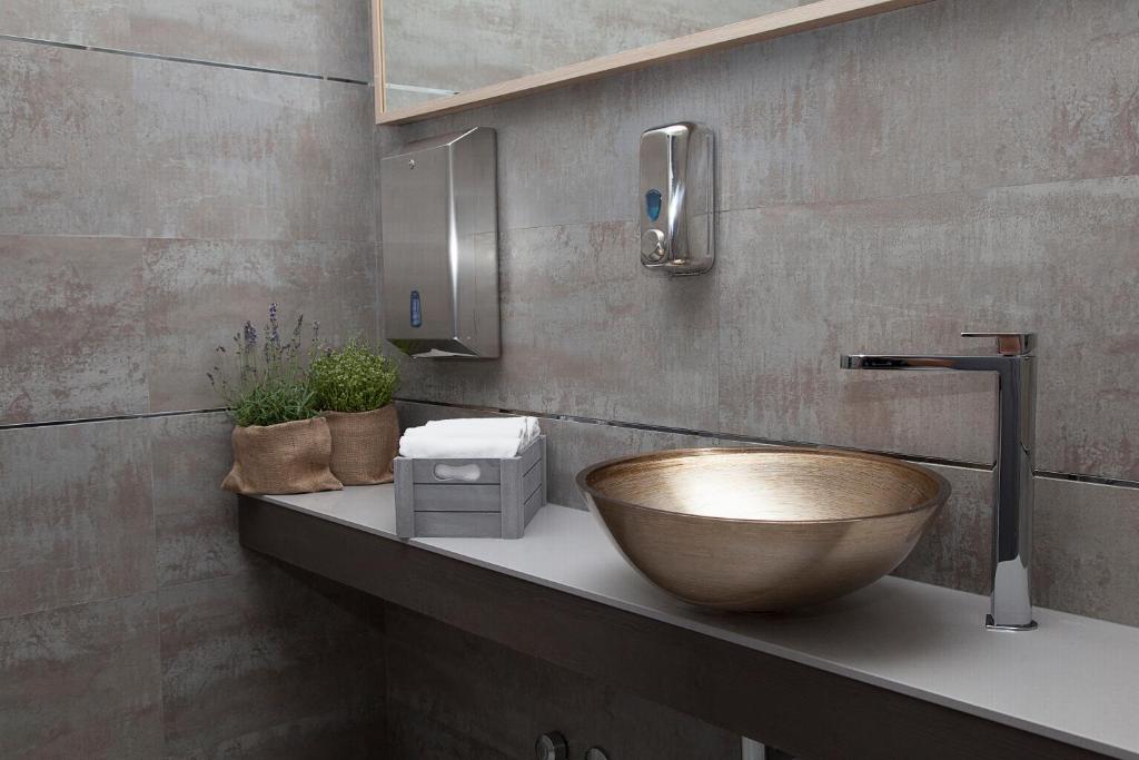 La salle de bains est pourvue d'un lavabo en bois sur un comptoir. dans l'établissement Hotel Helvetia, à Lido di Jesolo