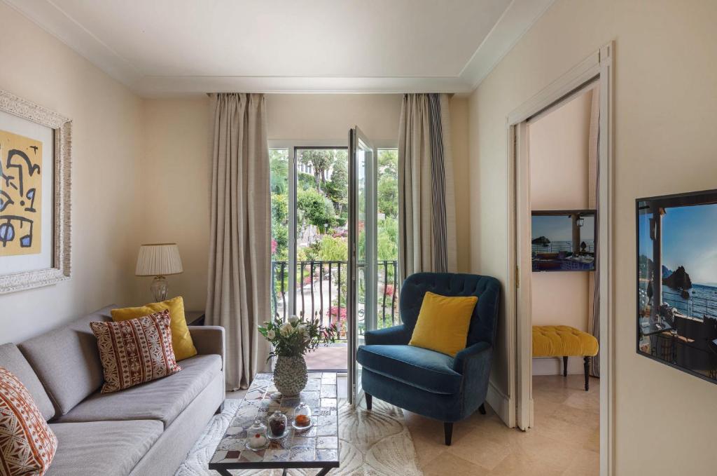 un salon avec un canapé et une chaise dans l'établissement Villa Sant'Andrea, A Belmond Hotel, Taormina Mare, à Taormine