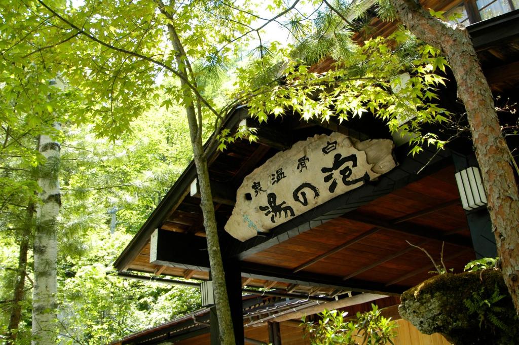 un panneau sur le côté d'une cabane dans les arbres dans l'établissement Awanoyu, à Matsumoto