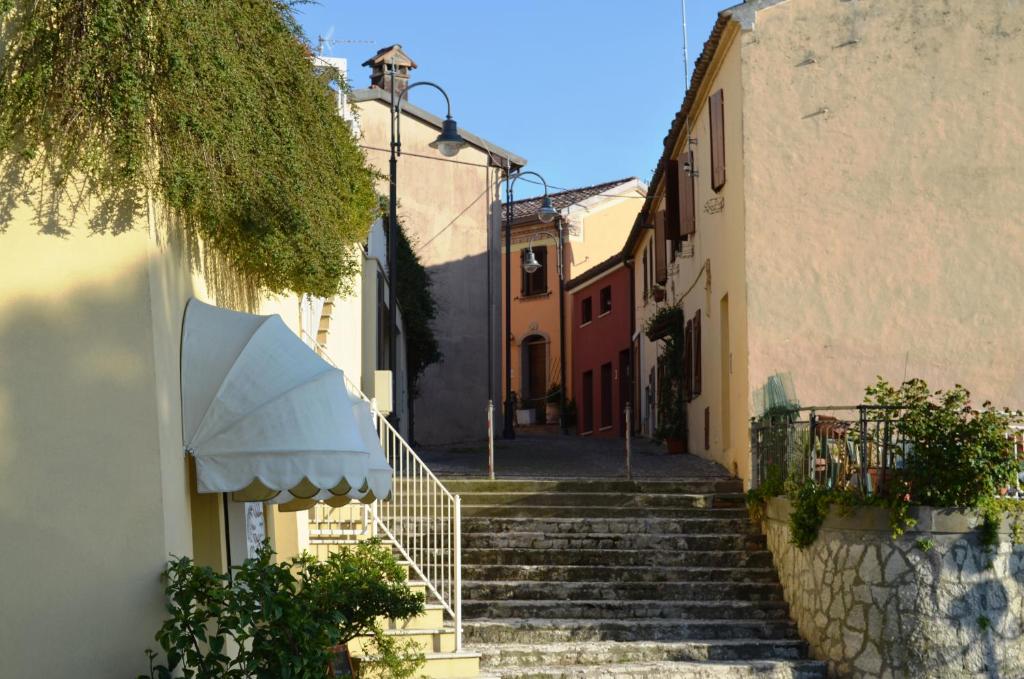 un groupe d'escaliers menant à un bâtiment avec un parapluie dans l'établissement Hotel Everest - Bar e Ristorante, à Gabicce Mare