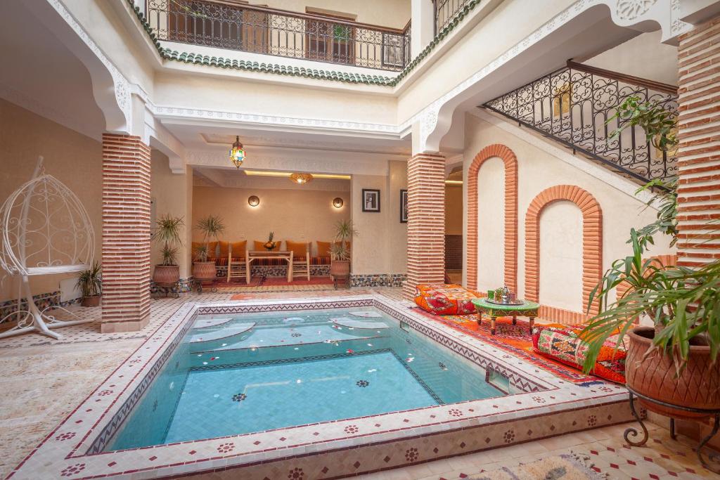 une grande piscine dans un grand bâtiment dans l'établissement Riad Salman, à Marrakech