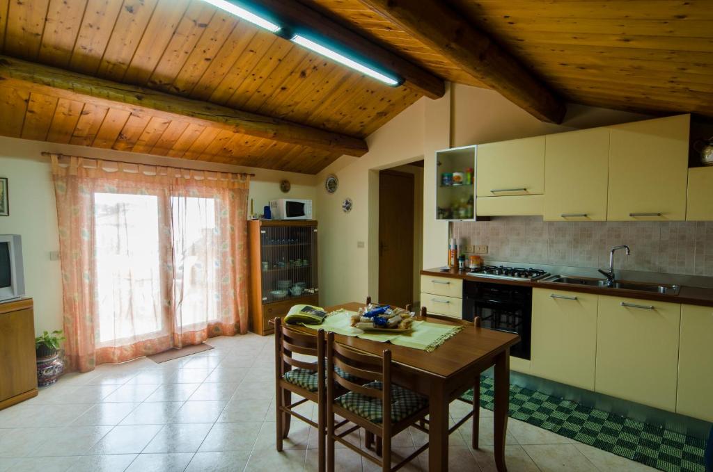 une cuisine avec un plafond en bois et une table avec des chaises dans l'établissement Casa Vacanza AcquaMarina, à Acireale