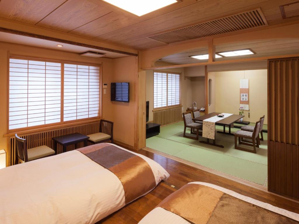 une chambre avec deux lits, une table et des chaises dans l'établissement Shogetsu Grand Hotel, à Jozankei