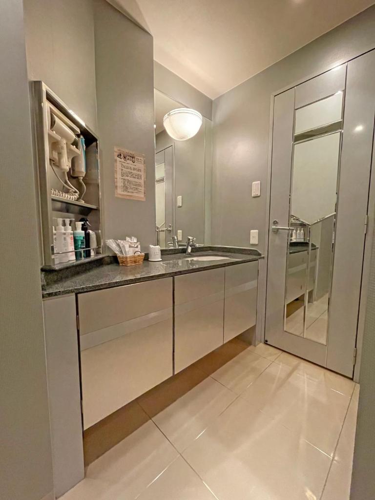 une salle de bain avec un lavabo et un miroir dans l'établissement HOTEL THE i Adult only, à Higashiōsaka