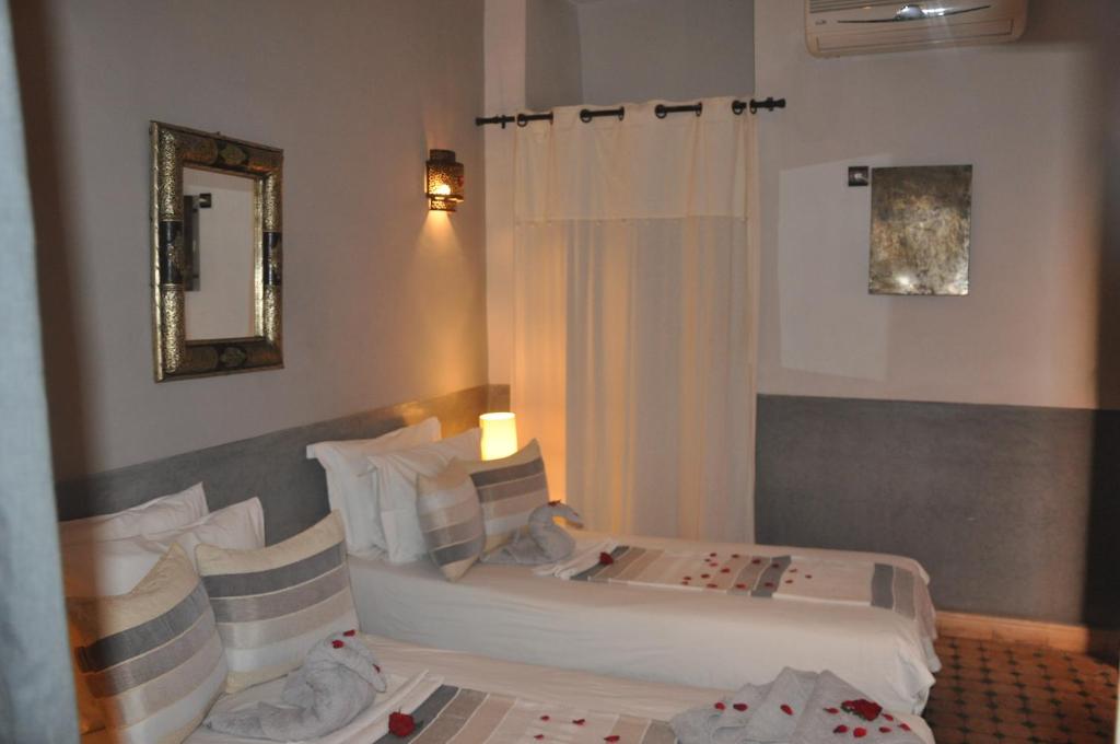 une chambre d'hôtel avec deux lits et un miroir dans l'établissement Riad des Etoiles, à Marrakech