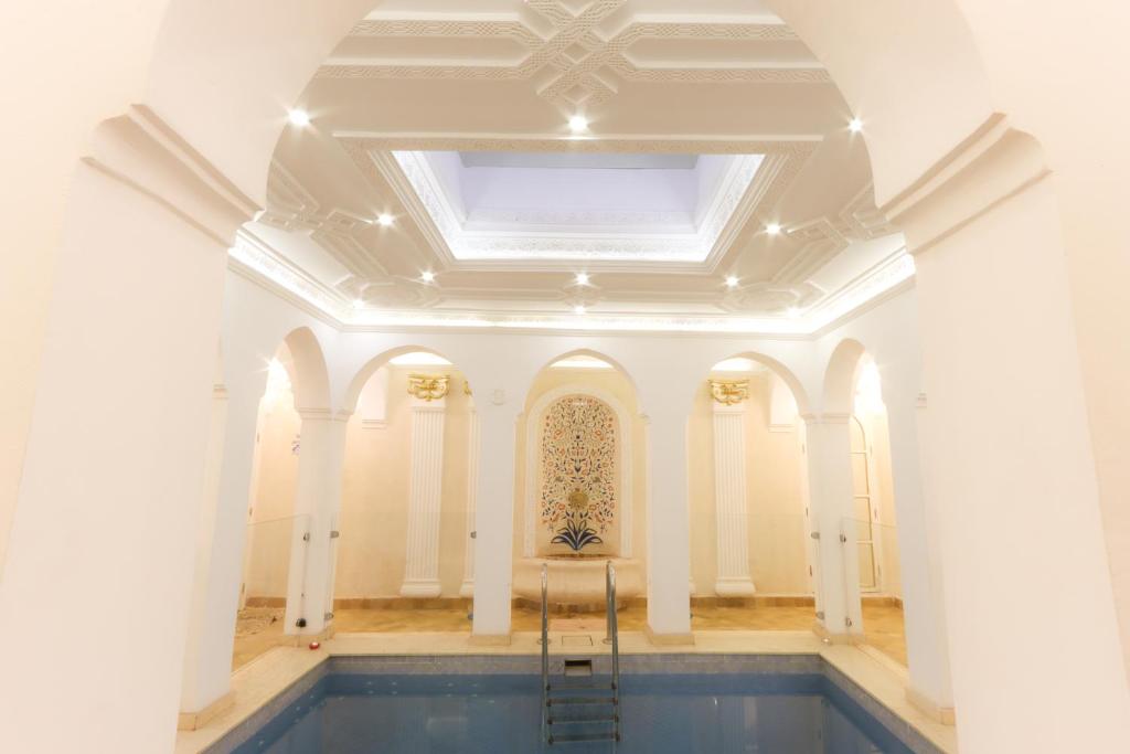 Cette grande chambre dispose d'un plafond et d'une piscine. dans l'établissement Riad Palais Des Princesses & Spa, à Marrakech