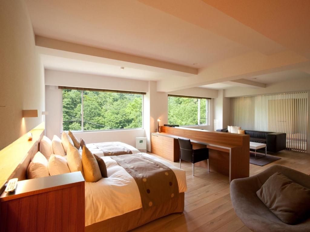 une chambre avec un grand lit et un bureau dans l'établissement Bourou NOGUCHI Noboribetsu (Adult Only), à Noboribetsu
