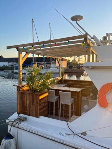 un bateau avec une table et des chaises sur l'eau dans l'établissement Exceptionnel bateau maison reine mathilde, à Ouistreham