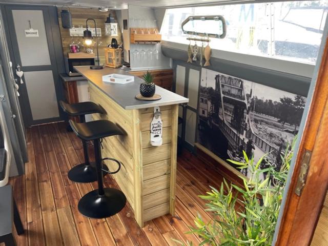 - une cuisine avec un comptoir et deux tabourets dans une pièce dans l'établissement Exceptionnel bateau maison reine mathilde, à Ouistreham 5 autres photos