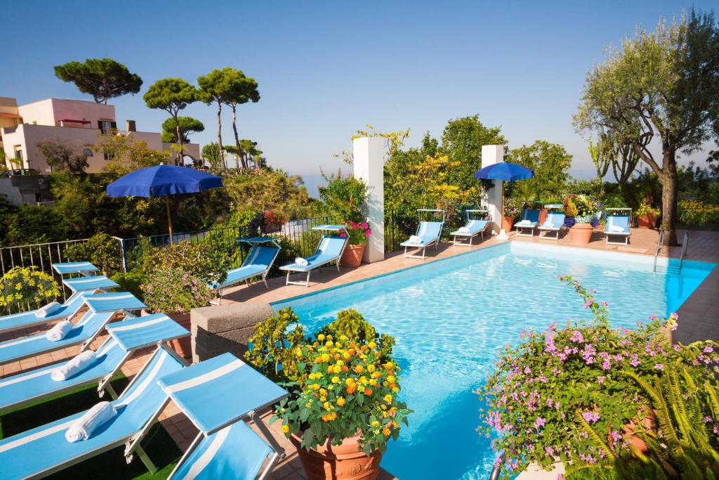 une piscine avec chaises longues et parasols dans l'établissement Hotel Gran Paradiso, à Ischia
