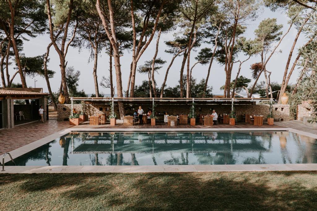 un lieu de mariage avec une piscine et des arbres dans l'établissement Praia Art Resort - Small Luxury Hotels of the world, à Le Castella