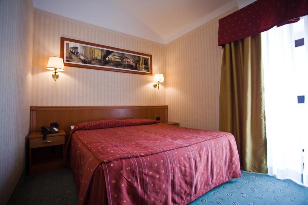 une chambre d'hôtel avec un lit et une fenêtre dans l'établissement Palace Hotel San Michele, à Monte SantʼAngelo