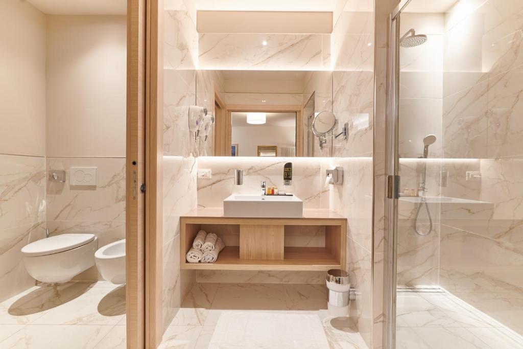 une salle de bain avec une douche, des toilettes et un lavabo dans l'établissement Lake Front Hotel Brenzone, à Brenzone