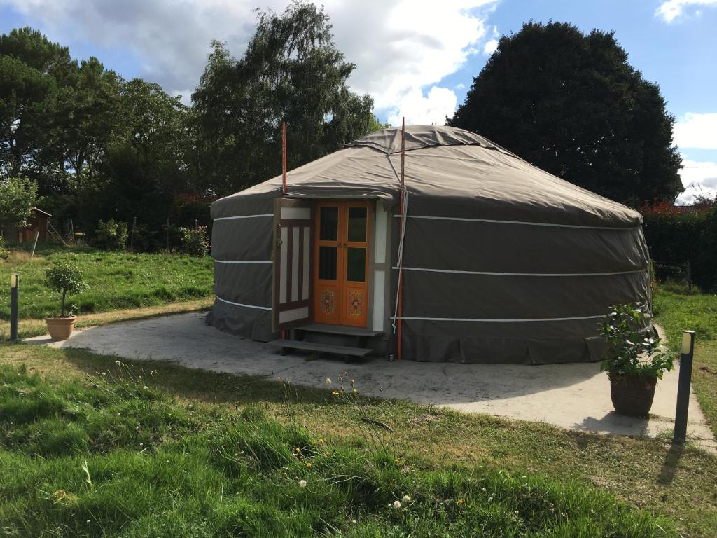 une grande tente en forme de dôme avec une porte dans une cour. dans l'établissement La Dorépontaise YOURTE MONGOLE, à Pondaurat