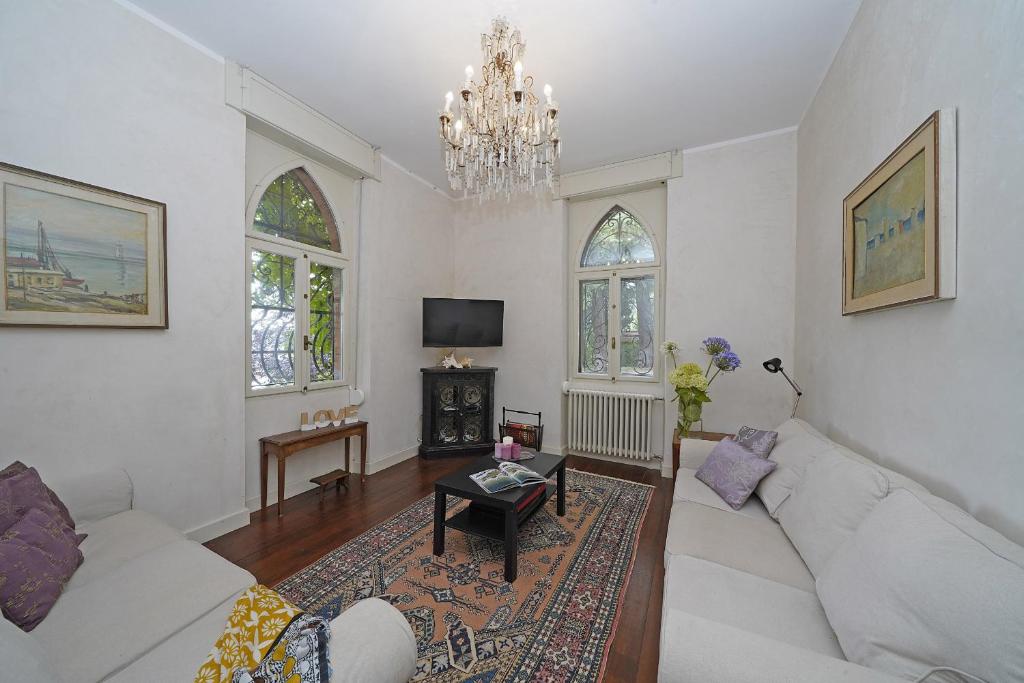 d'un salon avec un canapé blanc et un lustre. dans l'établissement Villa Maria, à Salò