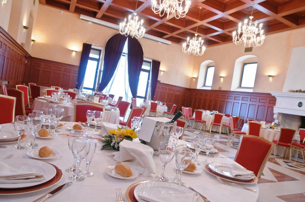 une salle à manger avec tables, chaises et lustres dans l'établissement Palace Hotel San Michele, à Monte SantʼAngelo
