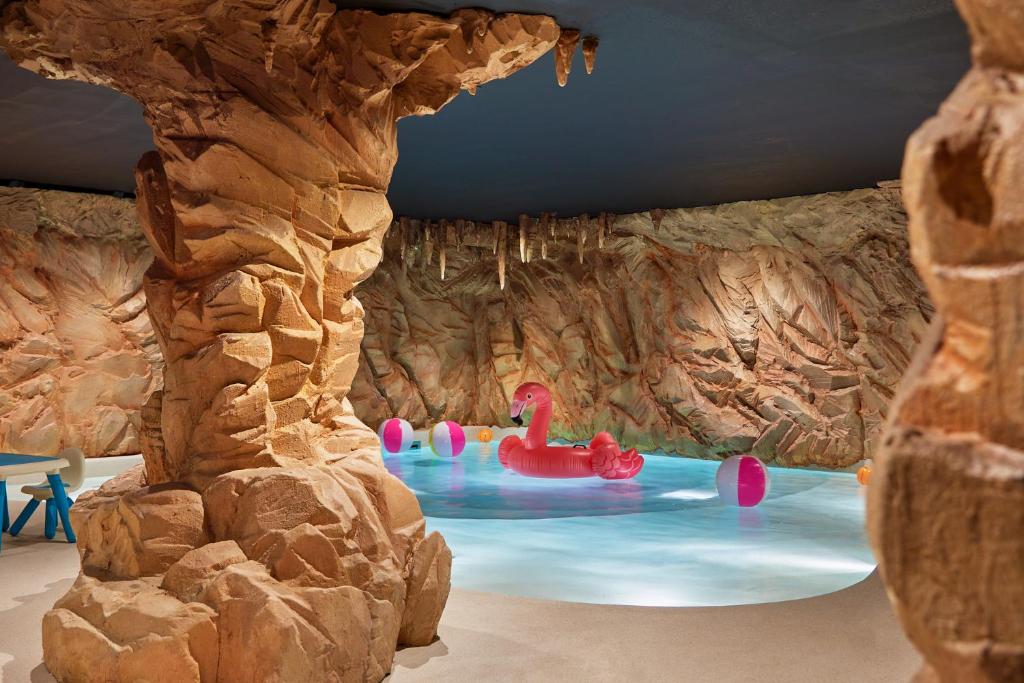 - un parc aquatique avec des cygnes dans une grotte dans l'établissement Airelles Val d'Isère, à Val dʼIsère