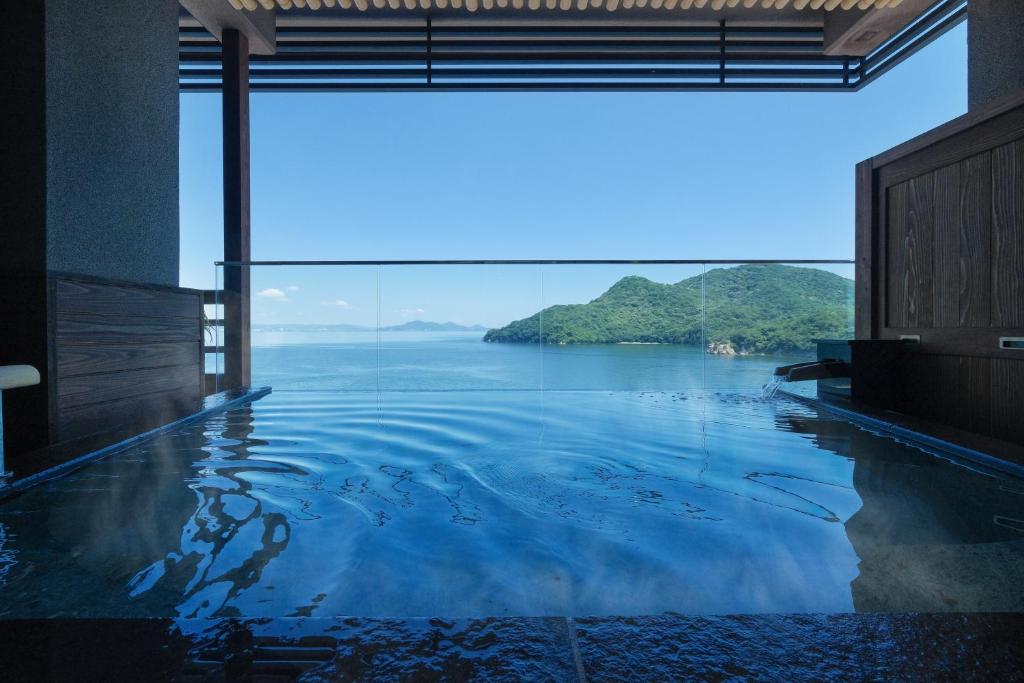 une piscine avec vue sur l'eau dans l'établissement Keishokan Sazanamitei, à Fukuyama