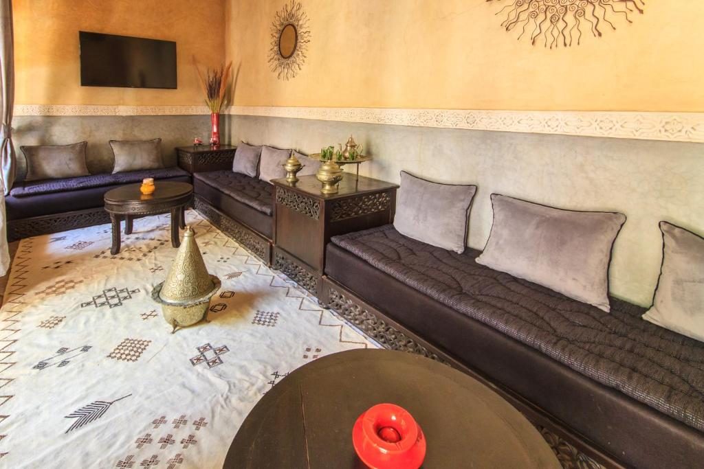 un salon avec des canapés en cuir et une télévision dans l'établissement Riad Nabila, à Marrakech