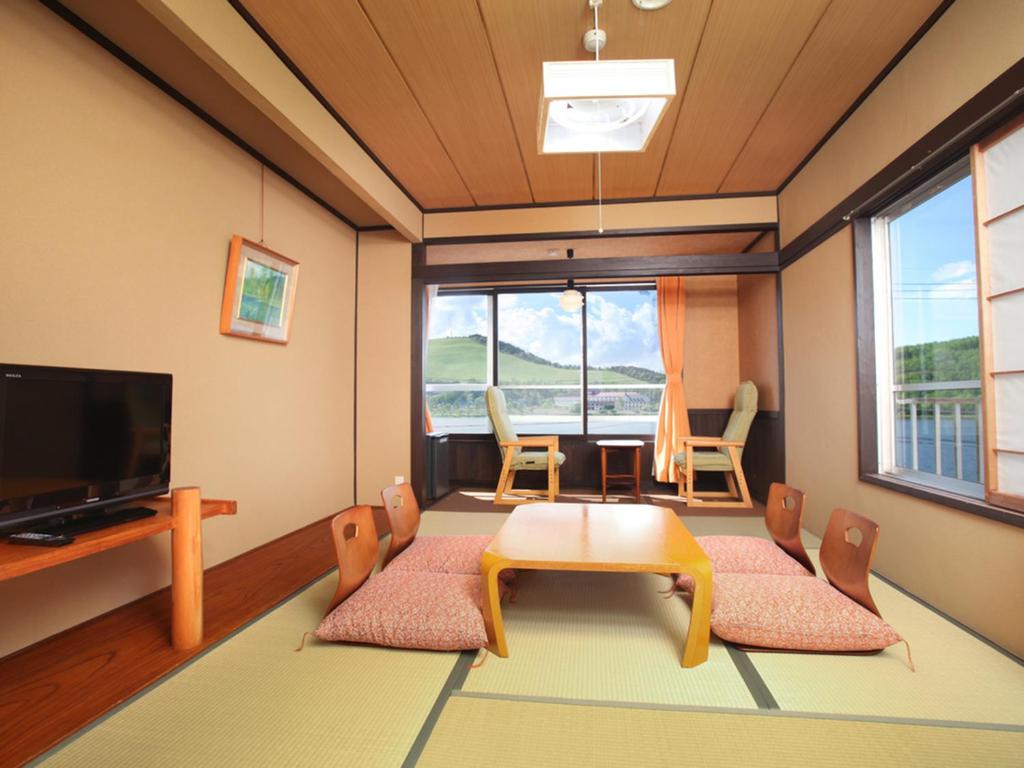 - un salon avec une table, des chaises et une télévision dans l'établissement Kimimachisou, à Chino 37 autres photos
