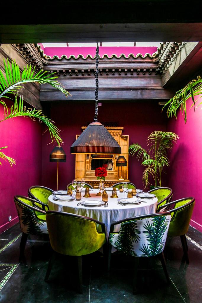 une salle à manger avec une table et des chaises vertes dans l'établissement Riad Fes - Relais & Châteaux, à Fès