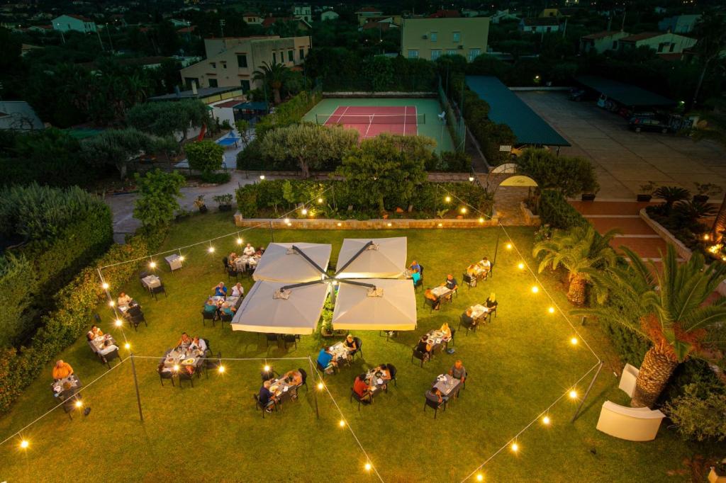 Vue de tête d'un groupe de personnes dans un parc éclairé dans l'établissement Hotel Baia Del Capitano, à Cefalù