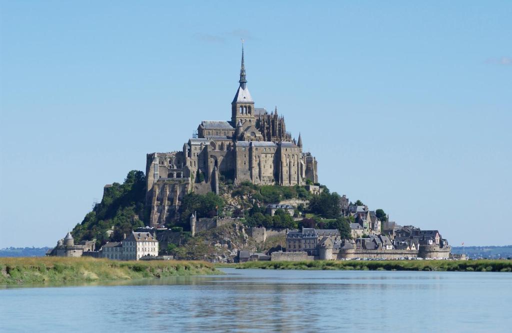 un château sur une île dans l'eau dans l'établissement Village de Gîtes de l'Anse de Moidrey, à Moidrey