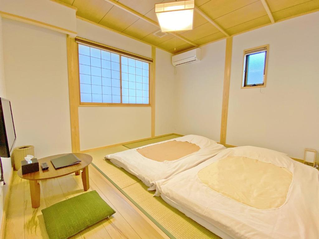 - une chambre avec un lit, une table et une fenêtre dans l'établissement 寅家 Japanese modern hotel, à Gero