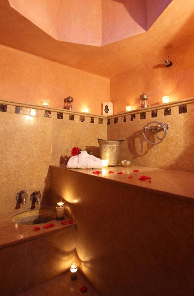La salle de bains est pourvue d'un lavabo et d'une baignoire avec des bougies. dans l'établissement Riad ILayka, à Marrakech 37 autres photos