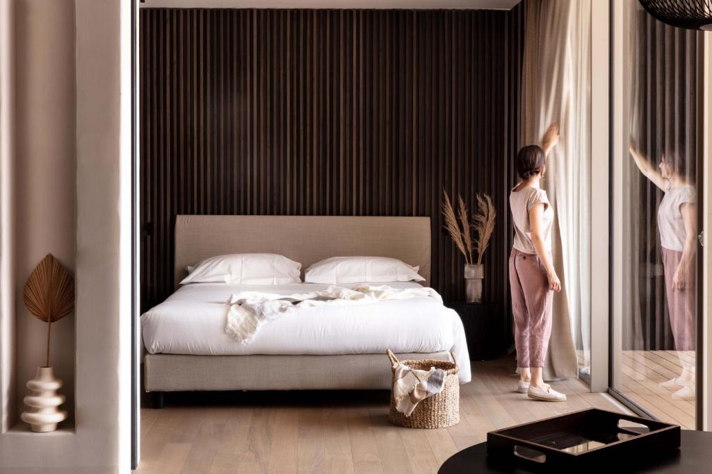 une femme debout à côté d'un lit dans une chambre dans l'établissement Laqua by the lake, à Pettenasco 18 autres photos