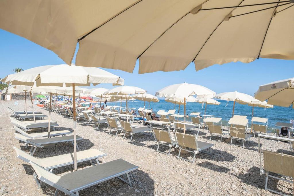 un groupe de chaises et de parasols sur une plage dans l'établissement Hotel Del Sole, à Santa Marinella