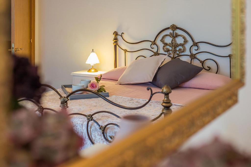 - une chambre avec un lit doté d'oreillers roses et d'un miroir dans l'établissement Casale Lucy, à Pergola