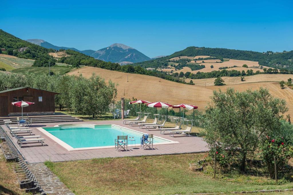 - une piscine avec des parasols, des tables et des chaises dans l'établissement Casale Lucy, à Pergola