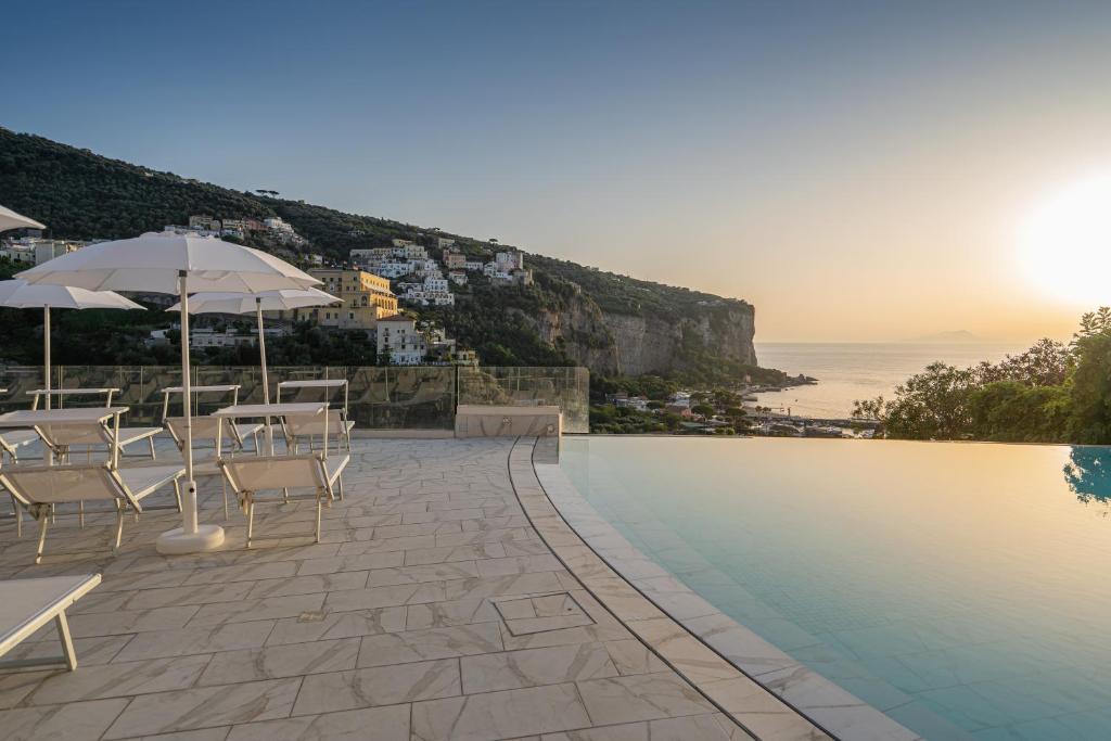 une piscine avec chaises et parasols au bord de l'océan dans l'établissement Hotel Mary, à Vico Equense